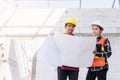 Architect and client discussing the plan with blueprint of the building at construction site Royalty Free Stock Photo