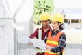 Architect and client discussing the plan with blueprint of the building at construction site Royalty Free Stock Photo