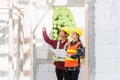 Architect and client discussing the plan with blueprint of the building at construction site Royalty Free Stock Photo