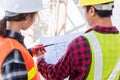 Architect and client discussing the plan with blueprint of the building at construction site Royalty Free Stock Photo