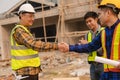 Architect and construction engineer holding hands while working for teamwork and cooperation concept after completing