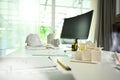 Architect desk with house model, blueprints, safety helmet and computer monitor on white table Royalty Free Stock Photo