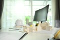 Architect desk with house model, blueprints, safety helmet and computer monitor on white table Royalty Free Stock Photo