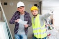 Architect discussing workflow with builder at construction site indoors Royalty Free Stock Photo