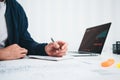 Young man designer sketching a construction project at notebook and drawing plan while working at office