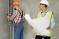 An architect with drawings in his hands. Man supervises construction work with builder. Foreman in house under Royalty Free Stock Photo
