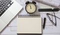 Architect engineer blank notebook, laptop and alarm clock on construction project blueprints background Royalty Free Stock Photo