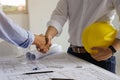 Architect and engineer shaking hands after finish an agreement in the office construction site, success collaboration concept Royalty Free Stock Photo