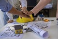 Architect engineers shake hands with hats and houses on construction tool tables. with blueprints on the table - business teamwork Royalty Free Stock Photo