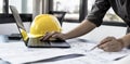 Architect engineers are using laptops to check house plans and print them out on paper after designing.