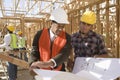 Architect And Foreman Having Discussion Over Blueprint