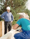 Architect or foreman watching a builder