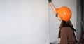 architect in hardhat measuring wall using steel ruller. architecture and home renovation Royalty Free Stock Photo