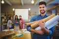 Architect holding blueprints while standing in creative office Royalty Free Stock Photo