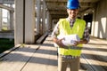 Architect holding rolled up blueprints at construction site Royalty Free Stock Photo