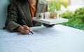 An architect holding and working on an architecture house model with shop drawing paper in the office Royalty Free Stock Photo