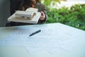 An architect holding and working on an architecture house model with shop drawing paper in the office Royalty Free Stock Photo