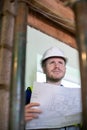 Architect Inside House Being Renovated Studying Plans