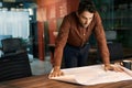 Architect leaning over an office table and reading blueprints Royalty Free Stock Photo