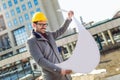 Architect in protective helmet holding blueprint Royalty Free Stock Photo