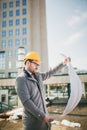 Architect in protective helmet holding blueprint outdoors Royalty Free Stock Photo