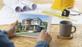 Architect reviewing modern house design on digital tablet with blueprints and tools Royalty Free Stock Photo