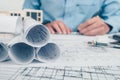 Architect rolls and plans on the table and architect engineer use pen drawing design working on blueprint. House planning design Royalty Free Stock Photo