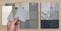 architect\'s hand holding quartz samples. materials construction on wood background. interior samples design.