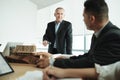 Architect Showing Miniature Building At Business Meeting With Client Royalty Free Stock Photo