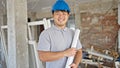architect smiling confident holding blueprints at construction site Royalty Free Stock Photo