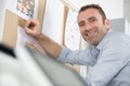 architect smiling and putting blueprint on office board Royalty Free Stock Photo