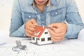 The architect takes a triangle ruler to measure the small house model on the drawing