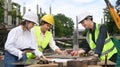 Architect team and engineer supervisor wearing safety helmet working, checking plan together at construction site Royalty Free Stock Photo