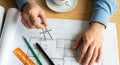 Architect Using Compass on Blueprints at Desk Royalty Free Stock Photo