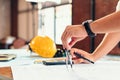 Architect using divider compass working on blueprint. blueprints, ruler, calculator, safety hat and book on the table. Royalty Free Stock Photo