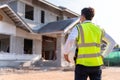 Architect watching some details and hold a helmet on a construction, House builder concept