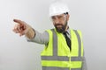 Architect wearing reflecting jacket and hardhat showing and pointing with finger