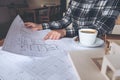 An architect working on an architecture model with shop drawing paper and coffee cup Royalty Free Stock Photo