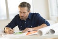 Architect Working On Blueprint At Desk Royalty Free Stock Photo