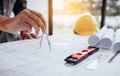 Architect working on blueprint in workplace and drawing compass. Royalty Free Stock Photo