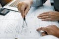 Architect working on blueprint in workplace with partnership and drawing compass Royalty Free Stock Photo