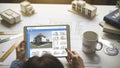 Architect working on building design with tablet and blueprints Royalty Free Stock Photo