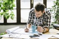 Architect working on freelance renovation project in his cool home office studio