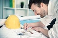 Architect working on his projects papers with compass Royalty Free Stock Photo