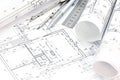 Architect workspace with floor plan, blueprint rolls, drawing compass, ruler and pencil Royalty Free Stock Photo