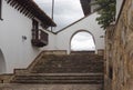 Architectonical details of Guatavita, colombian town. A white stone arc with stone floor a balcony and ceramic wooden roof