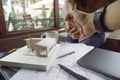 An architects and businessman shaking hand with architecture model with shop drawing paper