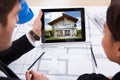 Architects with digital tablet looking at house Royalty Free Stock Photo