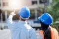 Architects And Engineer at a construction site looking at blueprints and pointing