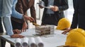 Architects and engineers collaborating on a building project discussing blueprints and using a scale model for visualization and Royalty Free Stock Photo